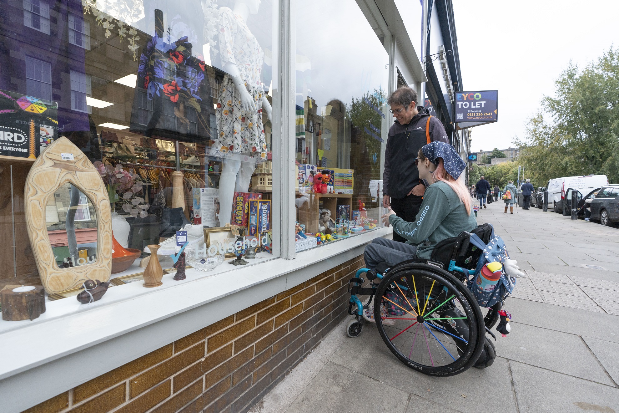 An image of two people looking into a shop window